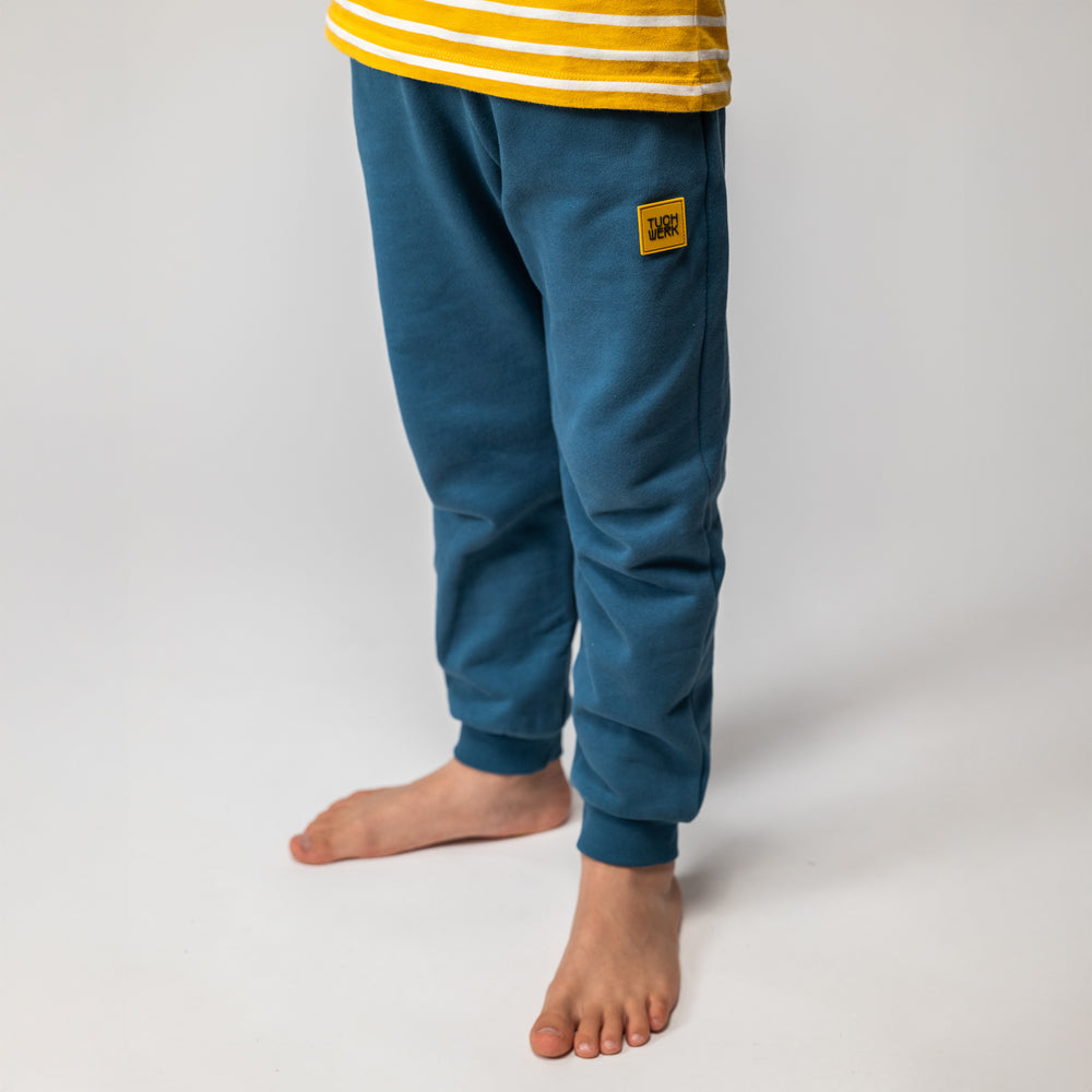 Unisex-Jogginghose für Kinder aus Bio-Baumwolle, gefertigt aus French Terry/Sommersweat, mit breitem Gummizug und seitlichen Taschen, fair produziert in Portugal.