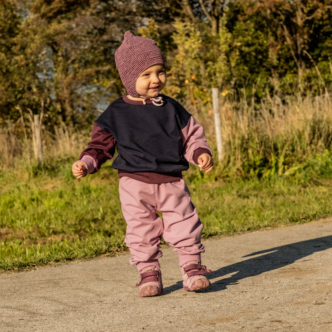 Kind trägt den leichten Sweater aus Bio-Baumwolle von Tuchwerk, bequem geschnitten für Bewegungsfreiheit und Komfort.